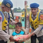 Anggota Satpolairud Polrestabes Palembang membagikan beras kepada anak yatim dan penyandang disabilitas di pesisir Sungai Mus