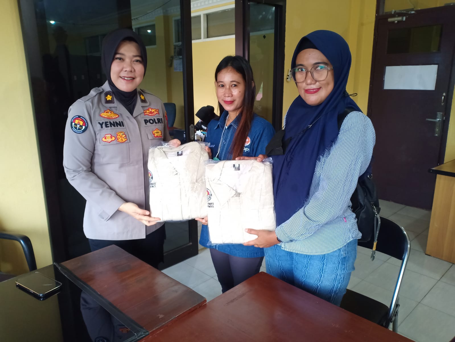 Kasubbid Penmas Bid humas, Kompol Yenni Diarty SIK saat memberikan rompi kepada salah satu wartawan