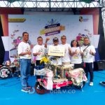 Direktur Utama Bank Mandiri Taspen Elmamber Sinaga berfoto bersama Sukandar, pemenang Grandprize sepeda listrik, dalam puncak acara HUT ke-8 Bank Mandiri Taspen di halaman DPRD Sumsel (Indodaily.co)