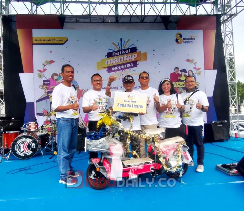 Direktur Utama Bank Mandiri Taspen Elmamber Sinaga berfoto bersama Sukandar, pemenang Grandprize sepeda listrik, dalam puncak acara HUT ke-8 Bank Mandiri Taspen di halaman DPRD Sumsel (Indodaily.co)