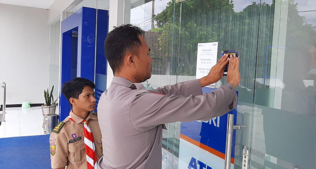 Personel Polsek Banjarsari saat pemasangan sticker kamtibmas di salah satu bank