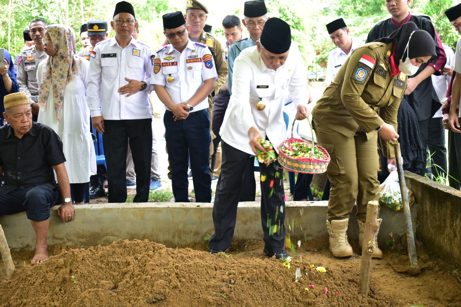 Bupati OKI, H Iskandar SE saat menabur bunga usai upacara pemakaman almarhum Kepala Satpol PP dan Damkar Kabupaten Ogan Komering Ilir, Drs Abdurrahman MSi