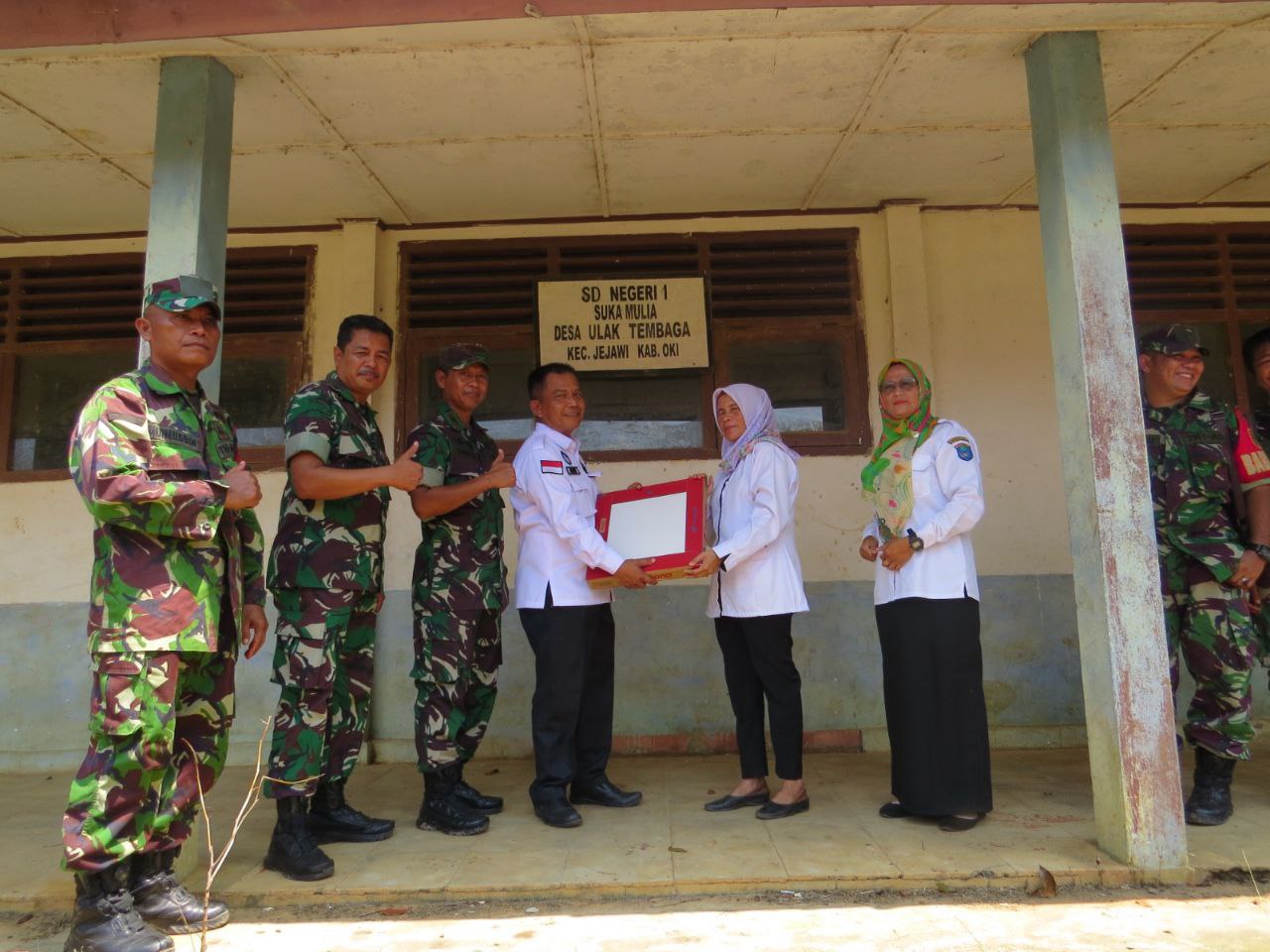 Kasdim 0402/OKI Mayor Czi Saipul Anwar mewakili Dandim 0402/OKI saat memberikan bantuan 125 kotak keramik secara simbolis kepada Kepala Sekolah SD Negeri 1 Suka Mulya